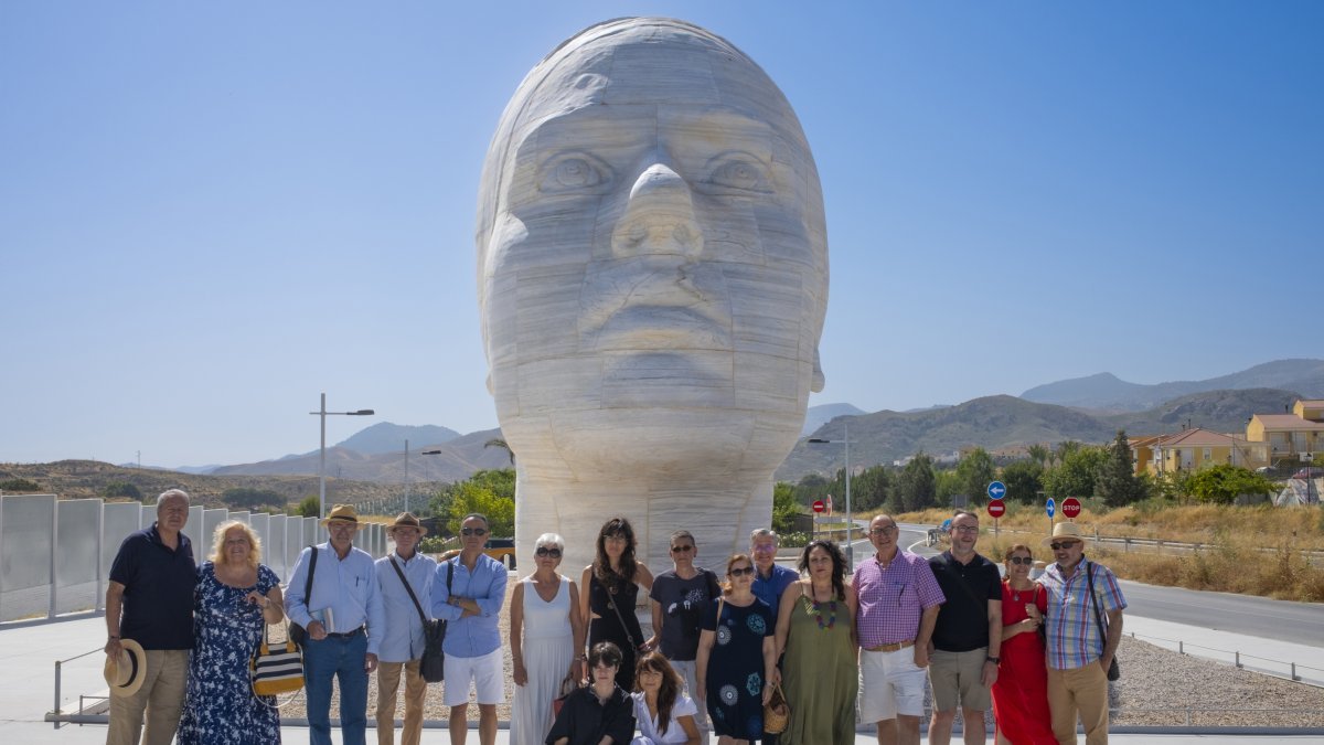 Participantes de la colección Cuentos en el paraíso junto a una escultura al aire libre